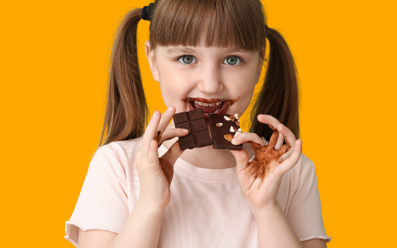 Glückliches Kind, das Schokolade isst.